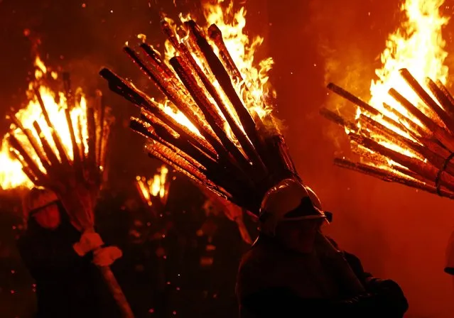 Carnival revellers carry burning wooden sticks as they take part in the traditional Swiss Chienbaese celebration in Liestal near Basel February 22, 2015. (Photo by Ruben Sprich/Reuters)