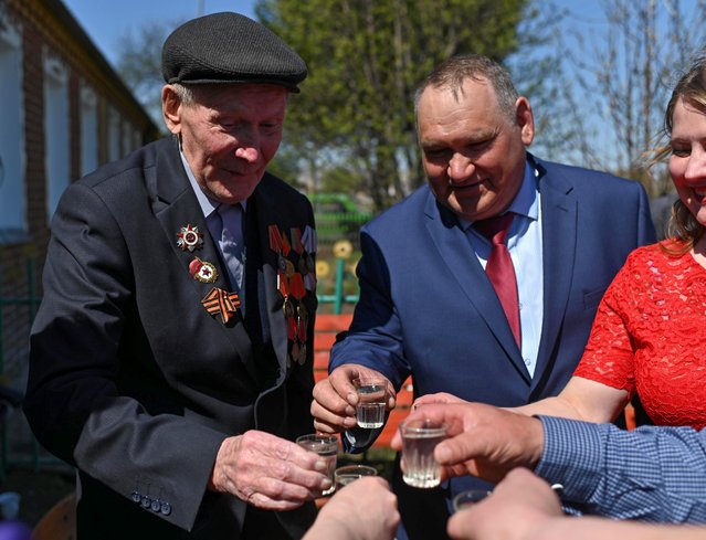 World War Two veteran Mikhail Gorbunov toasts with participants of a concert and local officials while receiving congratulations on Victory Day, which marks the 76th anniversary of the victory over Nazi Germany, in the settlement of Chernyayevo in Omsk Region, Russia on May 9, 2021. (Photo by Alexey Malgavko/Reuters)