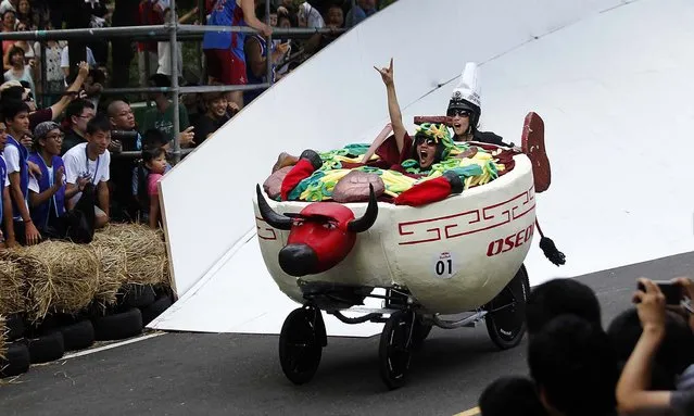 Drivers of a traditional Taiwanese beef noodle soup “soapbox” racer maneuver through the downhill course of the Red Bull Soapbox Race in Taipei, Taiwan, on September 29, 2013.  Racers judged on time and creativity competed for the top prize: a trip to the November 2013 Macau Grand Prix. (Photo by Wally Santana/Associated Press)