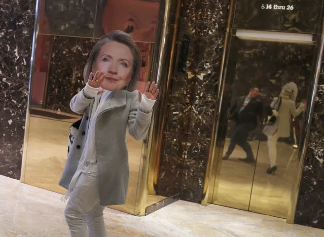 A man wearing a Hillary Clinton mask walks through Trump Tower on December 8, 2016 in New York. (Photo by Dominick Reuter/AFP Photo)