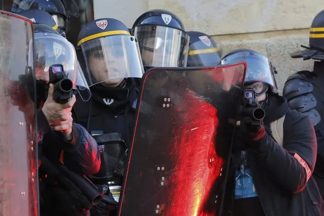 French riot police take cover behind shields as they clash with protesters during a demonstration to mark the one-year anniversary of a protest march in 2014 which ended in violence, in Nantes February 21, 2015. (Photo by Stephane Mahe/Reuters)