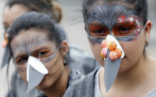 Actors dressed as pigeons perform at Bolivar Square in Bogota, Colombia, Tuesday, October 2, 2018. They urged pedestrians not to feed the large flocks of pigeons that descend each day as part of the city government's fight to control pigeon overpopulation through educational campaigns that urge people not to feed them. (Photo by Fernando Vergara/AP Photo)
