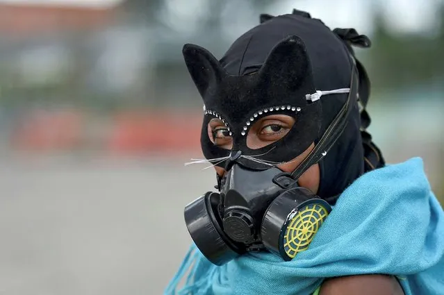 A demonstrator wears a cat eye mask and a gas mask during a protest against the government of Colombian President Ivan Duque, in Cali, Colombia, on May 22, 2021. (Photo by Luis Robayo/AFP Photo)