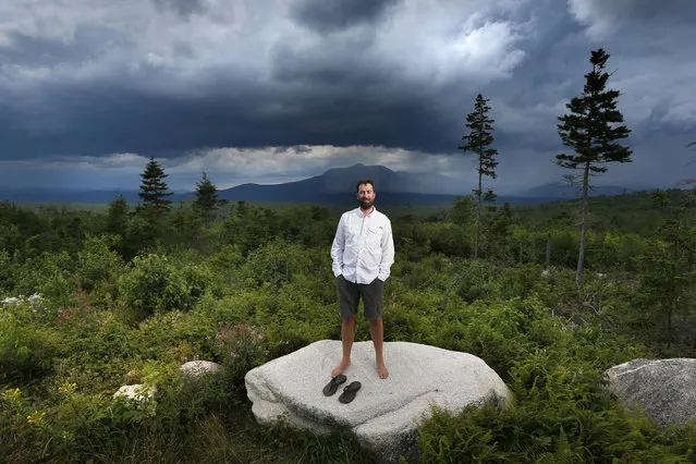 In this August 4, 2015 photo, Lucas St. Clair, the son of Burt's Bees founder Roxanne Quimby, poses on land proposed for a national park in Penobscot County, Maine. Mount Katahdin, the state's highest peak, can be seen in the background as a rainstorm passes through Baxter State Park. President Barack Obama in 2016 created the Katahdin Woods and Waters National Monument on 87,000 acres donated by Quimby. The backers of the new national monument in Maine don’t believe Donald Trump will undo Obama’s move. Lucas St. Clair, says he’s “pretty confident” that Trump won’t get involved. (Photo by Robert F. Bukaty/AP Photo)
