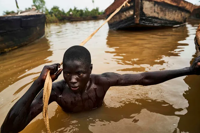 A Malian digger pulls his boat to a site where he can dive and collect sand from the Niger river bed near Kangaba, in Mali' s southwestern Koulikoro region, on October 2, 2018. (Photo by Michele Cattani/AFP Photo)