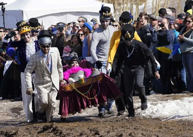 A team carrying a mock coffin runs around the muddy track in the Coffin Races at Frozen Dead Guy Days in Nederland, Colorado March 14, 2015. (Photo by Rick Wilking/Reuters)