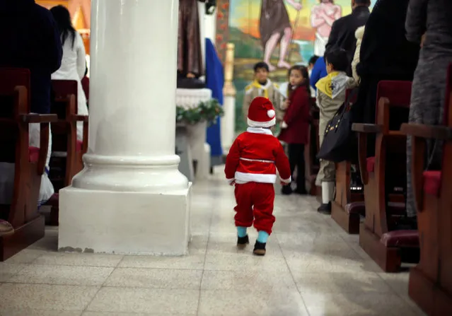 A Palestinian boy dressed as Santa Claus attends a mass ahead of Christmas at Der Latin church in Gaza City December 18, 2016. (Photo by Suhaib Salem/Reuters)