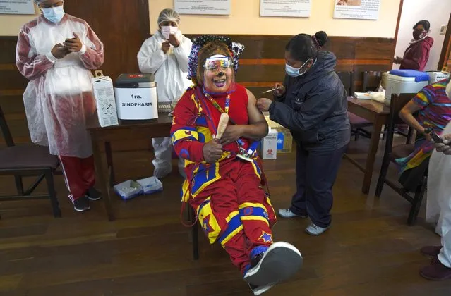 A health worker is injected with the Sinopharm COVID-19 vaccine to a clown during a vaccination campaign for people over 18 at the public University San Andres, in La Paz, Bolivia, Monday, July 5, 2021. (Photo by Juan Karita/AP Photo)