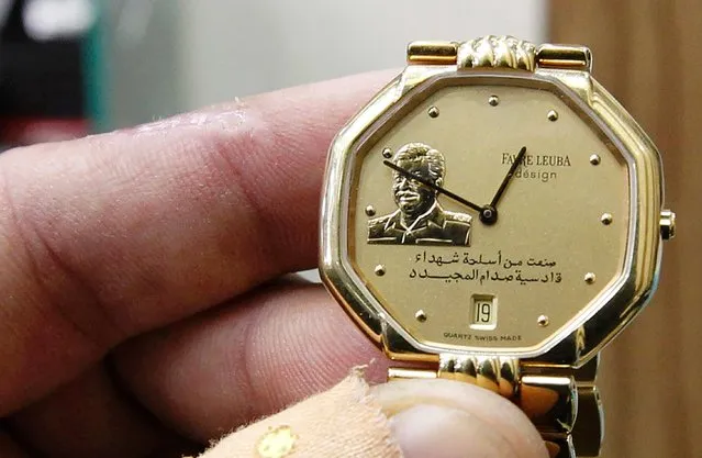 An Iraqi shopkeeper holds a watch bearing a portrait of late Iraqi president Saddam Hussein at his shop in the capital Baghdad on December 28, 2016. While Saddam was brutal to those who opposed him and led his country into two disastrous wars, there are those who still look back fondly on his time in power, especially in comparison to the years of devastating internal violence and ineffective governance that followed his overthrow in 2003. (Photo by Sabah Arar/AFP Photo)