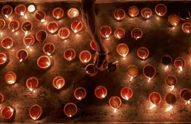 A devotee prepares to place oil lamps at a religious ceremony during the Diwali festival at Ponnambalavaneshwaram Hindu temple in Colombo, Sri Lanka on November 12,2023. (Photo by Dinuka Liyanawatte/Reuters)