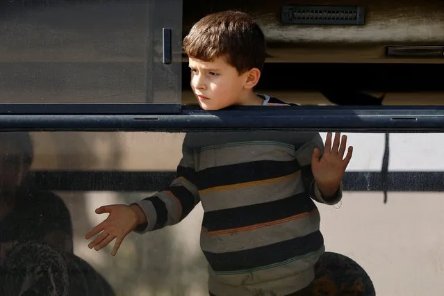 A boy looks out of a bus window as Palestinian holding a foreign passports waits for permission to leave Gaza, amid the ongoing conflict between Israel and Palestinian Islamist group Hamas, at the Rafah border crossing with Egypt, in Rafah in the southern Gaza Strip on November 3, 2023. (Photo by Ibraheem Abu Mustafa/Reuters)