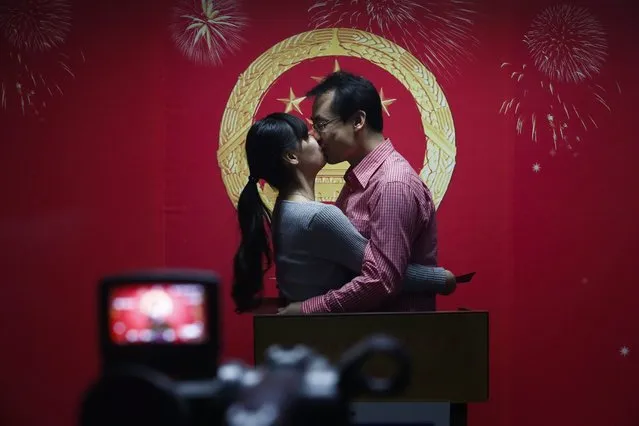 A Chinese couple kiss while being recorded on video during a symbolic ceremony of receiving marriage licenses on Valentine's Day at a marriage registry office in an eastern district of Beijing, China, 14 February 2016. Although celebrating 14 February as Valentine's Day is largely a foreign concept, many Chinese couples are beginning to embrace the idea as a novel day for couples in love to register for marriage. (Photo by Rolex Dela Pena/EPA)