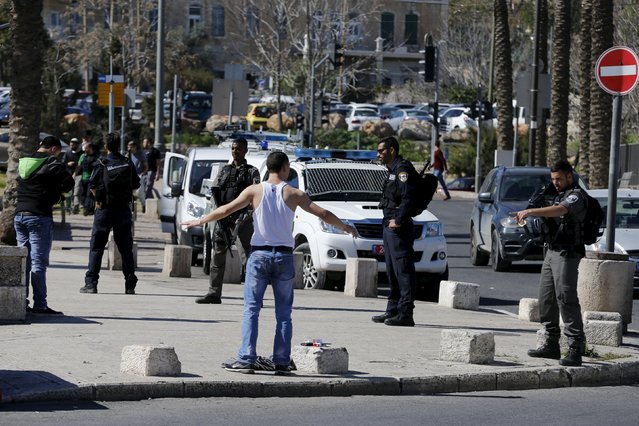 A Palestinian man lifts his arms before he is body searched by Israeli border police near Damascus Gate in Jerusalem's Old City February 16, 2016. (Photo by Ammar Awad/Reuters)