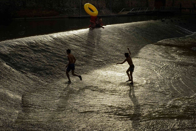 People cool off in water of the Arga River during a hot summer day in Pamplona, northern Spain, Wednesday, Aug. 11, 2021. (Photo by Alvaro Barrientos/AP Photo)