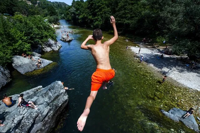 A boy jumps into the river Treska during a hot day, near Skopje, Republic of North Macedonia, 15 July 2021. A heat wave with temperatures around 40 degrees Celsius hit North Macedonia and the region. (Photo by Georgi Licovski/EPA/EFE)