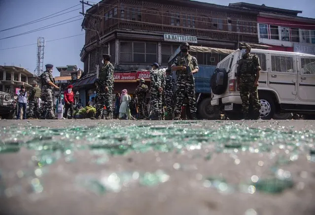Indian paramilitary soldiers keep guard near the site of a grenade attack in a market area in Srinagar, Indian controlled Kashmir, Tuesday, August 10, 2021. Several civilians were injured in the grenade attack which police have blamed on rebels fighting against Indian rule. (Photo by Mukhtar Khan/AP Photo)