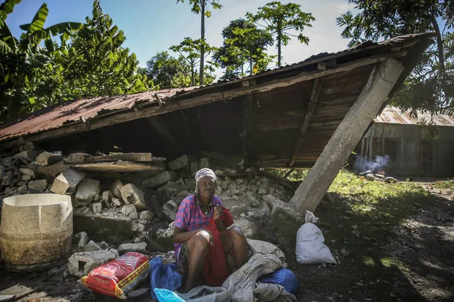A woman sits in front of a destroyed house after the earthquake in Camp-Perrin, Les Cayes, Haiti, Sunday, August 15, 2021. (Photo by Joseph Odelyn/AP Photo)