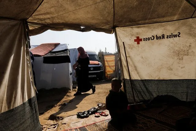 A displaced Palestinian woman walks past a tent as the conflict between Israel and Hamas continues, at Nasser hospital in Khan Younis, in the southern Gaza Strip on December 2, 2023. (Photo by Saleh Salem/Reuters)