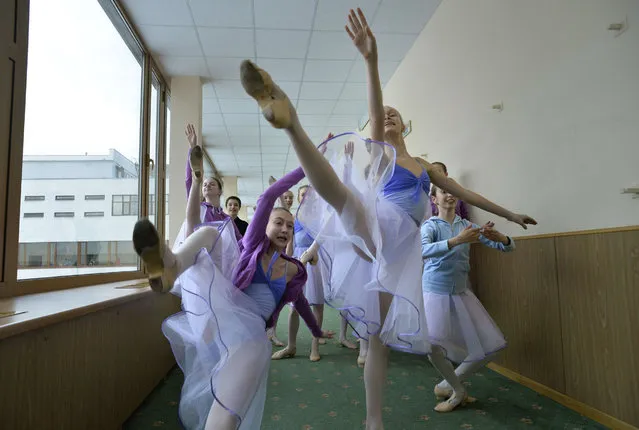 Students perform in a hallway before the start of a class in the Moscow State Academy of Choreography, better known as the Bolshoi Ballet Academy, in Moscow, on March 3, 2016. (Photo by Yuri Kadobnov/AFP Photo)