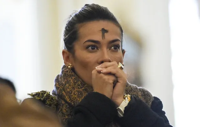 A Catholic faithful with her forehead marked with ash prays during the celebration of Ash Wednesday in Bogota on March 6, 2019. Ash Wednesday is a Christian holy day of prayer, fasting, and repentance. It is preceded by Shrove Tuesday and falls on the first day of Lent, the six weeks of penitence before Easter. (Photo by Juan Barreto/AFP Photo)
