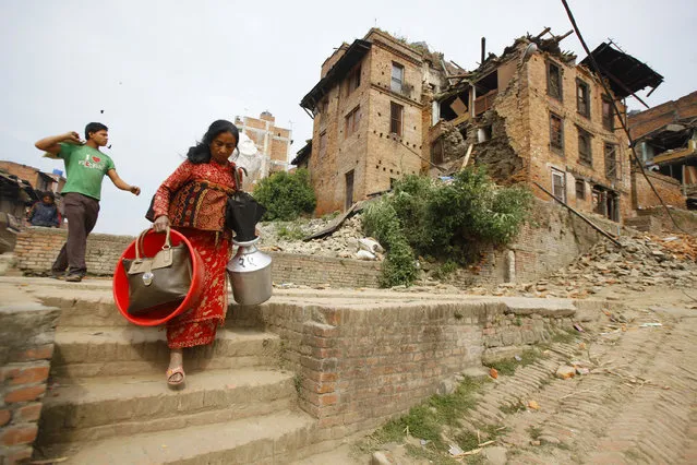 Nepalese evacuate with belongings to safer areas in Bhaktapur, Nepal, Sunday, April 26, 2015. (Photo by Niranjan Shrestha/AP Photo)