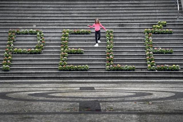 A girl walks among a floral arrangement for the late Brazilian soccer star Pele at the City Hall in Santos, Brazil, Friday, December 30, 2022. Pele, who played most of his career with Santos FC, died in Sao Paulo Thursday at the age of 82. (Photo by Matias Delacroix/AP Photo)
