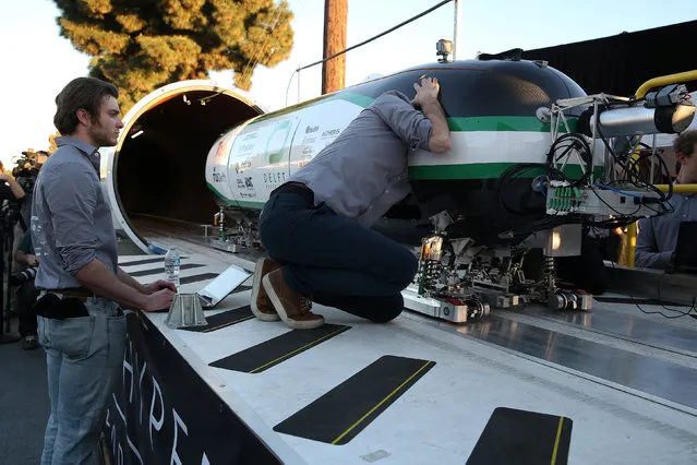 Team members from Delft Hyperloop, Delft University of Technology place their pod on the track during the SpaceX Hyperloop Pod Competition in Hawthorne, Los Angeles, California, U.S., January 29, 2017. (Photo by Monica Almeida/Reuters)