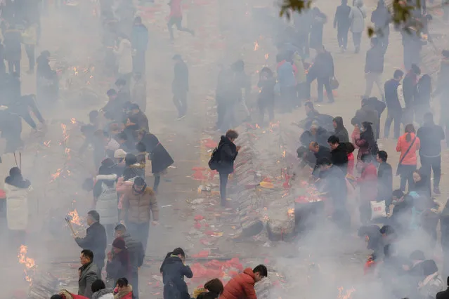 People burn incense to worship the God of Fortune at Guiyuan Temple on the fifth day of Chinese Lunar New Year, in Wuhan, Hubei province, China February 1, 2017. (Photo by Darley Shen/Reuters)