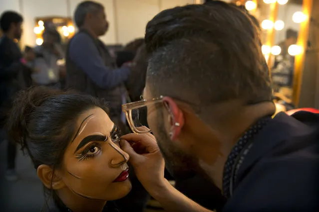 In this Thursday, March 14, 2019, photo, a makeup artist applies eyeliner to a model before a show during Lotus Makeup India Fashion Week, in New Delhi, India. (Photo by Manish Swarup/AP Photo)