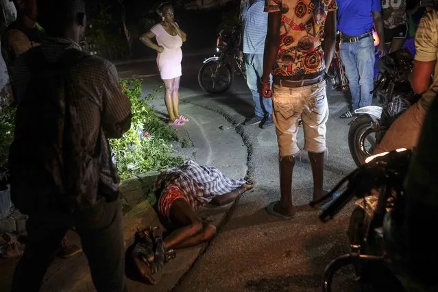 The body of a person lies on a street in the Petion-Ville neighborhood during a general strike in Port-au-Prince, Monday, Octoner 18, 2021. Workers angry about the nation's lack of security went on strike in protest two days after 17 members of a US-based missionary group were abducted by a violent gang. (Photo by Matias Delacroix/AP Photo)