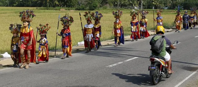 Penitents from the Mazon family and their relatives wear “Morions” masks and centurion garb as they walk along a highway during Holy Week celebrations in Mogpog, Marinduque in central Philippines March 22, 2016. (Photo by Erik De Castro/Reuters)