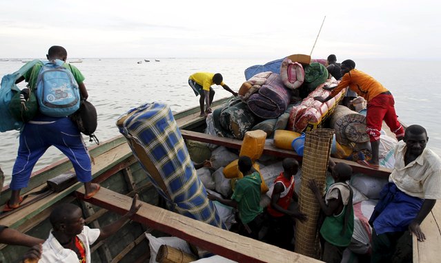 Burundian refugees carry their belongings as they board a boat on the shores of Lake Tanganyika in Kagunga village in Kigoma region in western Tanzania to Kigoma township, May 17, 2015. (Photo by Thomas Mukoya/Reuters)
