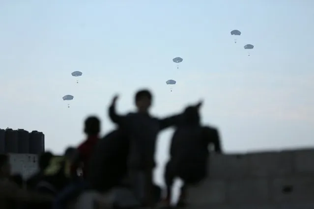The US military carries out its first aid drop over Gaza, on March 2, 2024. (Photo by Kosay Al Nemer/Reuters)