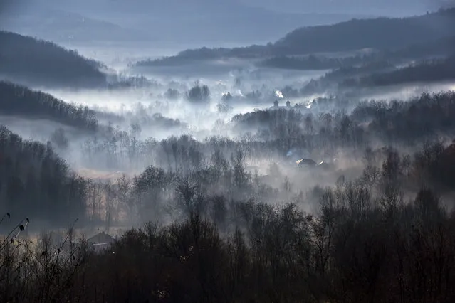 Morning fog engulfs a village outside Izbasesti, Romania, Tuesday, December 16, 2014. Severe fog affected large areas of Romania causing traffic disruptions. (Photo by Vadim Ghirda/AP Photo)