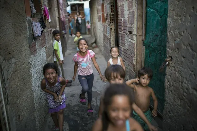 Children play at Los Hijos de Dios settlement, once an empty field owned by the government now occupied by about 60 families, in Caracas, Venezuela, Wednesday, May 8, 2019. More than 3 million Venezuelans have left their homeland in recent years amid skyrocketing inflation and shortages of food and medicine. U.S. administration officials have warned that 2 million more are expected to flee by the end of the year if the crisis continues in the oil-rich nation. (Photo by Rodrigo Abd/AP Photo)