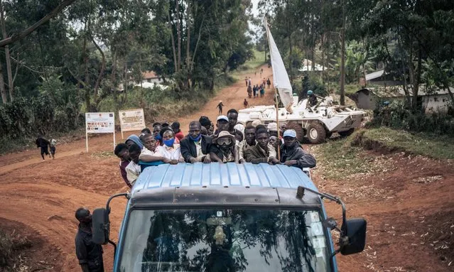 Red Cross volunteers leave Rhoo IDP camp to bury bodies in the village of Dhedja, escorted by soldiers from MONUSCO (the United Nations mission in DR Congo) on December 19, 2021, 60 kilometers from Bunia, the provincial capital of Ituri in northeastern Democratic Republic of Congo. Since late November, at least 100 people have been killed by militiamen in this area. Because of the insecurity and the presence of the militiamen, no one has been able to go and bury the bodies in Dhedja. For the past two years, thousands of armed men in the Ituri hills have been attacking villages, IDP camps and military positions in the name of the Cooperative for the Development of Congo, Codeco. (Photo by Alexis Huguet/AFP Photo)