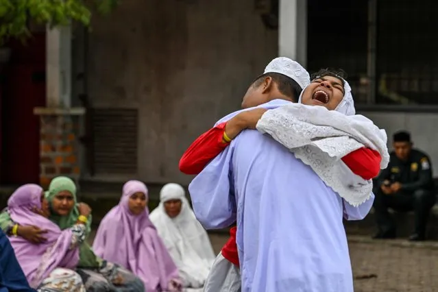 Rohingya refugees embrace each other after taking part in Eid al-Fitr prayers, marking the end of the holy month of Ramadan, at a temporary shelter in Meulaboh, Indonesia's Aceh province on April 10, 2024. (Photo by Chaideer Mahyuddin/AFP Photo)