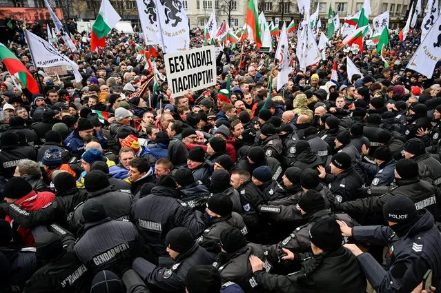 Around 2,000 protesters, who don't wear masks or adhere to social distancing, push against police cordons as they try to enter Bulgaria's parliament building during a demonstration organised by the nationalist Vazrazhdane political party, which is pushing for the abolition of the Covid-19 health pass in Sofia, on January 12, 2022. Bulgaria has the lowest vaccination rate in the European Union, with experts blaming hesitancy on low trust in the authorities and widespread conspiracy theories, as the country registered on January 12, 2022, a daily record of 7,062 new infections. (Photo by Nikolay Doychinov/AFP Photo)