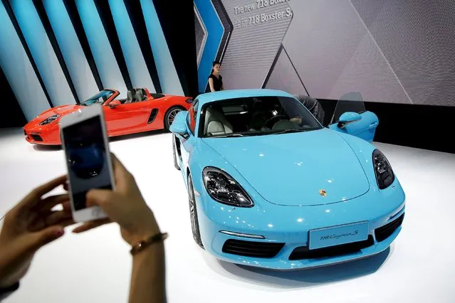 A visitor takes pictures of a new Porsche 718 Cayman S presented during Auto China 2016 auto show in Beijing April 25, 2016. (Photo by Damir Sagolj/Reuters)