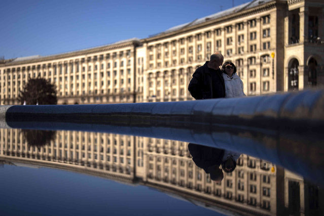 A couple walk along the Independence Square on a sunny morning in central Kyiv, Ukraine, Saturday, April 20, 2024. (Photo by Francisco Seco/AP Photo)
