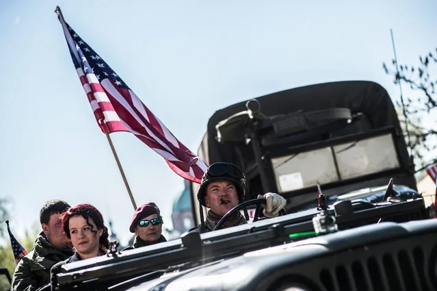 People, wearing US army WWII uniforms, attend the Convoy of Liberty event in Prague, Czech Republic, 29 April 2016. Convoy of Liberty commemorates the moments of 1945 when the western part of the country was liberated from Nazi oppression by the US Army. Military vintage cars from World War II by brands like Harley, Jeep, GMC, and others are represented in the convoy. The convoy's route in Prague traditionally makes its first stop in front of the US Embassy, where it will be welcomed by the Czech Army Military Band and many spectators. (Photo by Filip Singer/EPA)