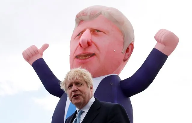 Britain's Prime Minister Boris Johnson speaks, with an inflatable figure depicting him in the background, at Jacksons Wharf Marina in Hartlepool following local elections, Britain, May 7, 2021. (Photo by Lee Smith/Reuters)