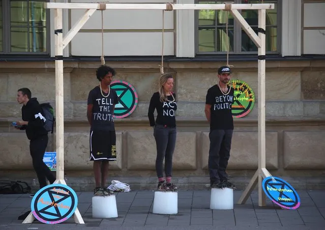 Activists stand on blocks of ice under makeshift gallows as they take part in the Global Climate Strike of the movement Fridays for Future, in Munich, Germany, September 20, 2019. At the same day the cabinet committee for climate protection negotiate about the details of the “climate change package” at the Federal Chancellery. (Photo by Michael Dalder/Reuters)