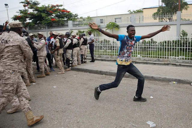 A protester opens his arms after slipping through the police cordon during a protest outside of the Legislative Palace in Port-au-Prince, Haiti, May 30, 2019. (Photo by Andres Martinez Casares/Reuters)