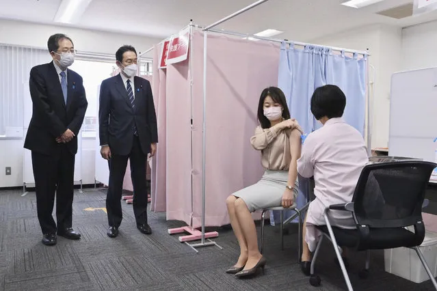 Japanese Prime Minister Fumio Kishida, second left, observes a vaccination site for staff members set up to protect against the coronavirus at the Haneda international airport in Tokyo, Saturday, February 12, 2022. Japan is considering easing its stringent border controls amid growing criticism that the measures, which have banned most foreign entrants including students and business travelers, are hurting the country's economy and international profile. (Photo by Japan Pool/Kyodo News via AP Photo)