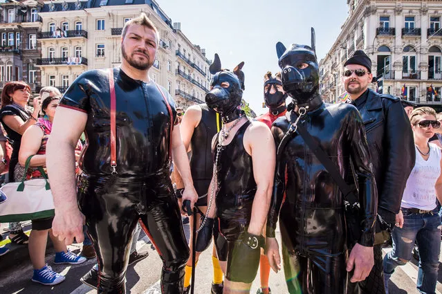 Men wearing latex suits pose for a photo during the annual gay pride in Brussels, Saturday, May 17, 2014. (Photo by Geert Vanden Wijngaert/AP Photo)