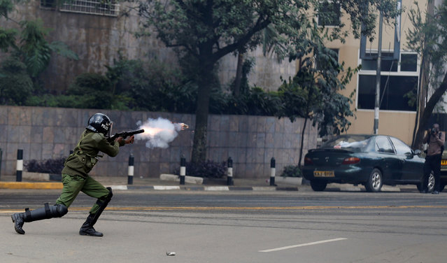 A riot policeman fires a teargas canister to disperse supporters of Kenya's opposition Coalition for Reforms and Democracy (CORD) during a protest at the premises hosting the headquarters of Independent Electoral and Boundaries Commission (IEBC) to demand the disbandment of the electoral body ahead of next year's election in Nairobi, Kenya, May 23, 2016. (Photo by Thomas Mukoya/Reuters)