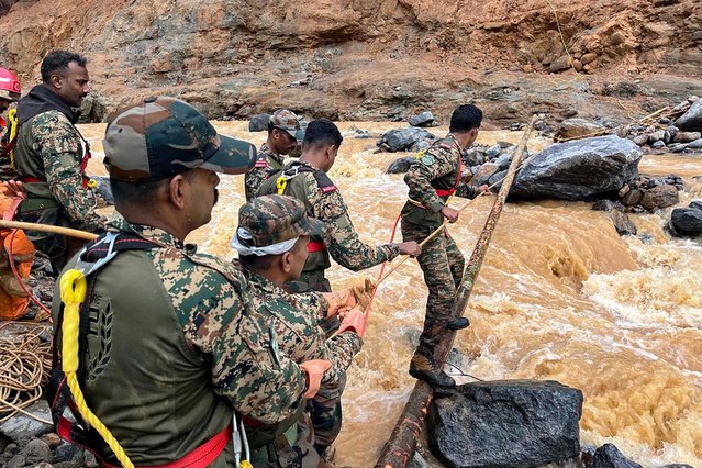 In this handout photograph taken on July 31, 2024 and released by the Indian Army, security and relief personnel conduct a search and rescue operation after landslides in Wayanad. Relentless downpours and howling winds on July 31, hampered search for survivors of landslides that struck Indian tea plantations and killed 126 people, most believed to be labourers and their families. (Photo by Indian Army/AFP Photo)