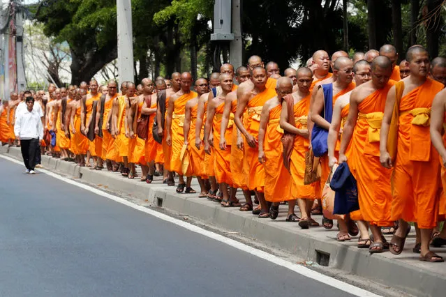 Buddhist monks walk from Wat Phra Dhammakaya temple to Khlongluang provincial police station to show support for Phra Dhammachayo, the influential Buddhist abbot charged with money-laundering and receiving illegal donations, in Pathum Thani province, north of Bangkok, Thailand, May 26, 2016. (Photo by Chaiwat Subprasom/Reuters)