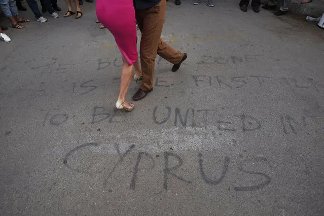 Greek and Turkish Cypriots dance a tango inside the United Nations-controlled buffer zone along Ledra Street in the medieval center of Cyprus' divided capital Nicosia Friday, June 9, 2017. The dancers gathered as part of a demonstration in support of talks aimed at reunifying the ethnically divided island. A United Nations spokesman said Friday that a summit meeting aiming to reach a breakthrough reunification deal will be held June 28 at Geneva, Switzerland. (Photo by Petros Karadjias/AP Photo)